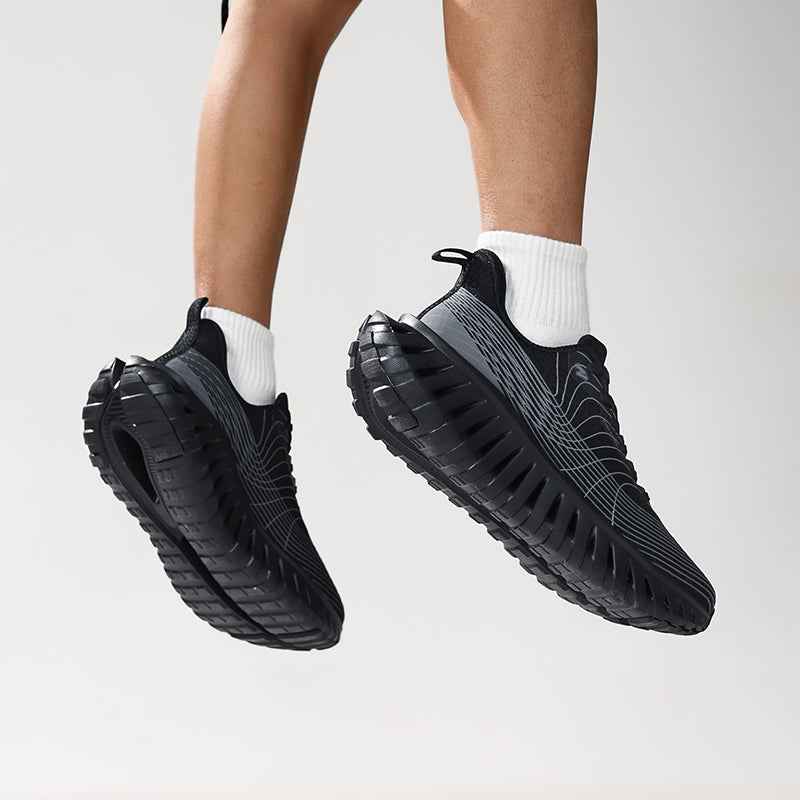 Swag Chic black sneakers with cushioned soles and white socks on feet mid-jump